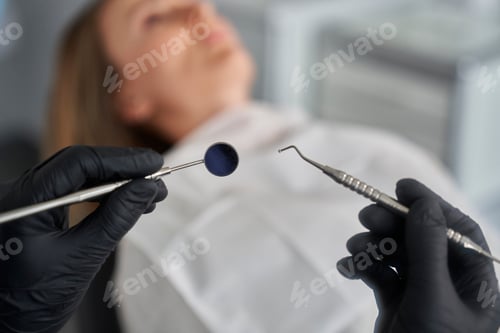 Preview: Dentist holding dental equipment over the patient