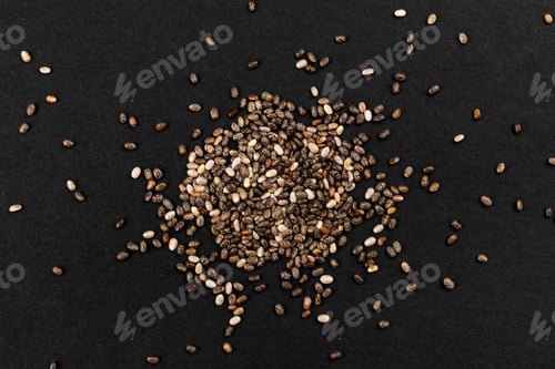 Preview: Pile of chia seeds on black background, top view