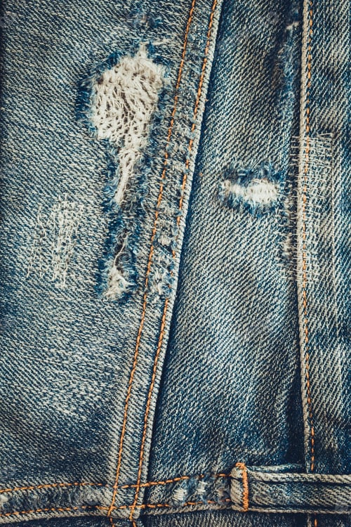 Preview: Torn jeans pocket denim background texture. Blue jeans fabric as material