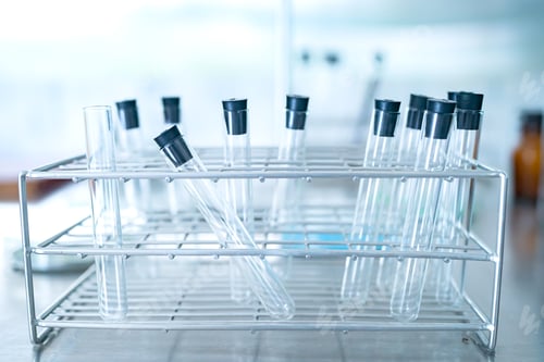 Preview: scientist doing research on plants holding a green solution in a test tube