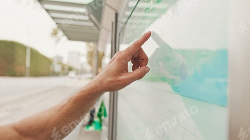 Preview: Close-up of unrecognizable man's hand pointing with finger searching public transport traffic