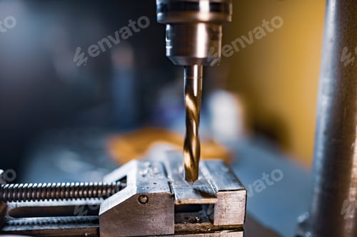 Preview: Drilling process with shavings close-up at the workplace in workshop
