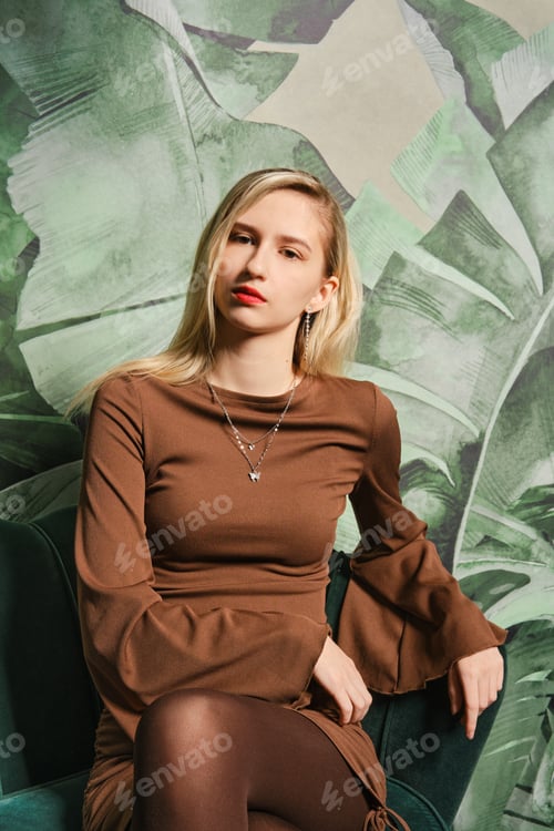 Preview: Young woman poses confidently in a stylish setting with tropical backdrop