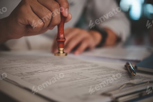 Preview: Man stamping approval of work finance banking or investment marketing documents on desk.