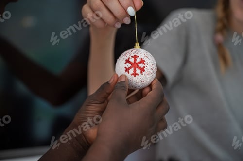 Preview: Hand of a child holding christmas bauble