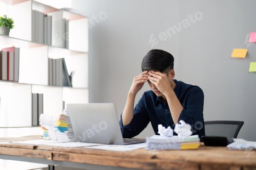 Preview: Young stressed businessman working in office. Angry businessman with too much work in office