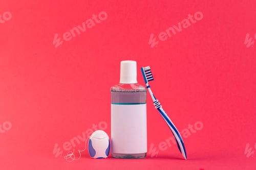 Preview: Oral care items arranged on a bright red background for dental hygiene routine