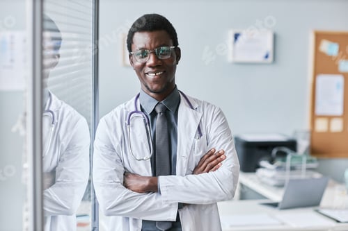 Preview: Confident black doctor leaning on glass wall in office smiling at camera