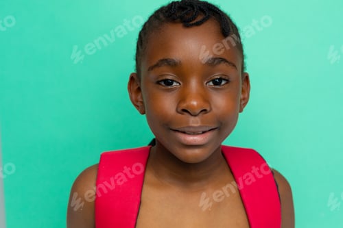 Preview: Portrait of african american schoolgirl with school bag over blue background at elementary school