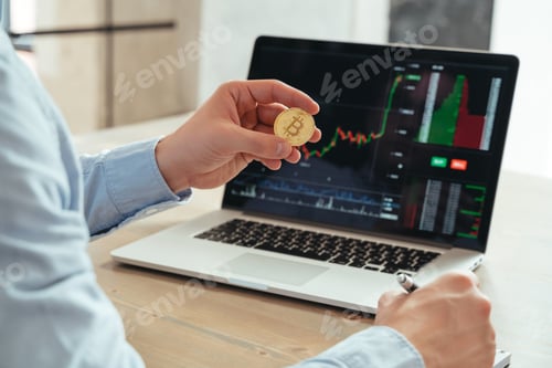 Preview: Cropped shot of trader investor holding bitcoin, using laptop, investing in cryptocurrency