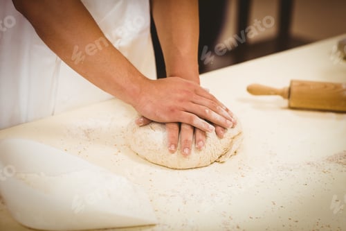 Preview: Baker kneading dough at a counter in a commercial kitchen