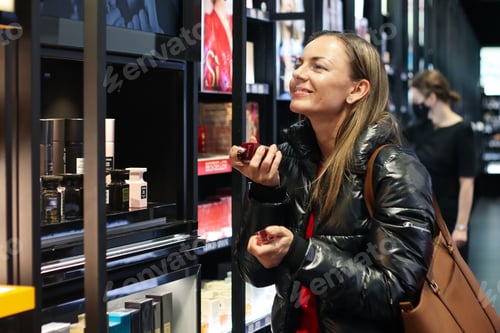 Preview: A woman chooses a perfume in a cosmetics store.Retail shopping,holiday shopping, candid portrait.