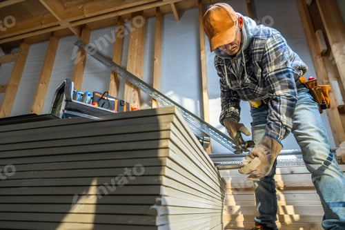 Preview: Carpenter Measuring Materials in a Construction Workshop During Early Morning Hours