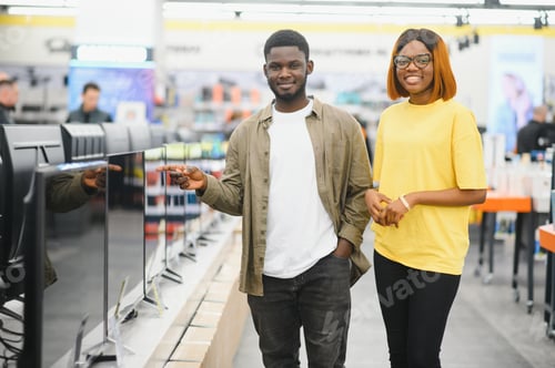 Preview: Beautiful couple buying consumer tech products in modern home appliances store.