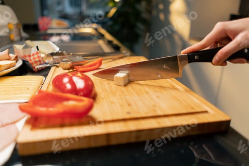 Preview: close-up of young girls hands slicing a feta cheese for salad preparing dinner