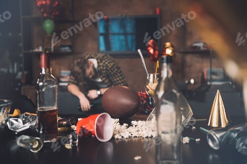 Preview: Drunk young man sleeping on couch in messy room after party
