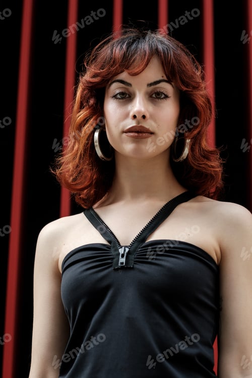 Preview: A young female model is looking at camera in front of striped red background.