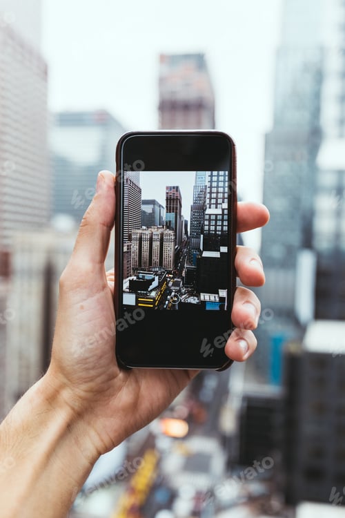 Preview: cropped shot fo man with smartphone taking picture of new york city