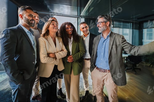 Preview: Confident businessman explaining strategy to a diverse team of colleagues in a modern office