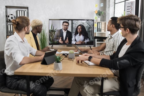 Vista previa: Focused multiracial business people in conference room, looking at a screen