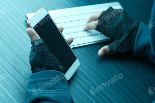 Preview: A hacker is diligently working on a smartphone while using a keyboard in a darkened environment