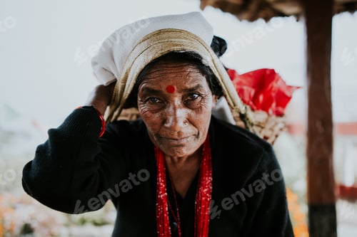 Preview: Nepali woman carrying bags wrapped around her forhead.