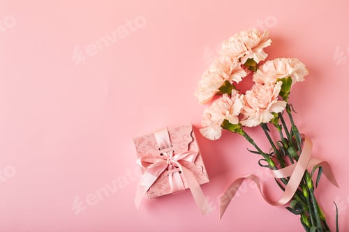 Preview: Bouquet of pink carnations and pink gift box. Design concept of holiday greeting with carnation