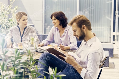 Preview: Business colleagues having break on terrace