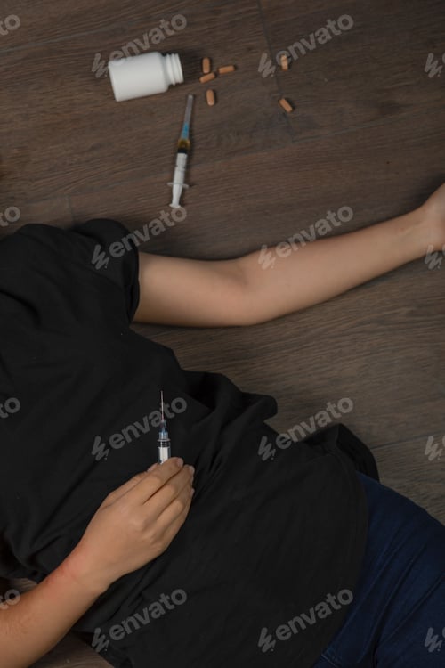Preview: Photo of addicted woman's body on the floor please injections and pills.