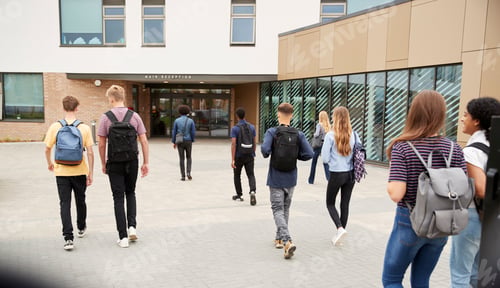 Preview: Rear View Of High School Students Walking Into College Building Together