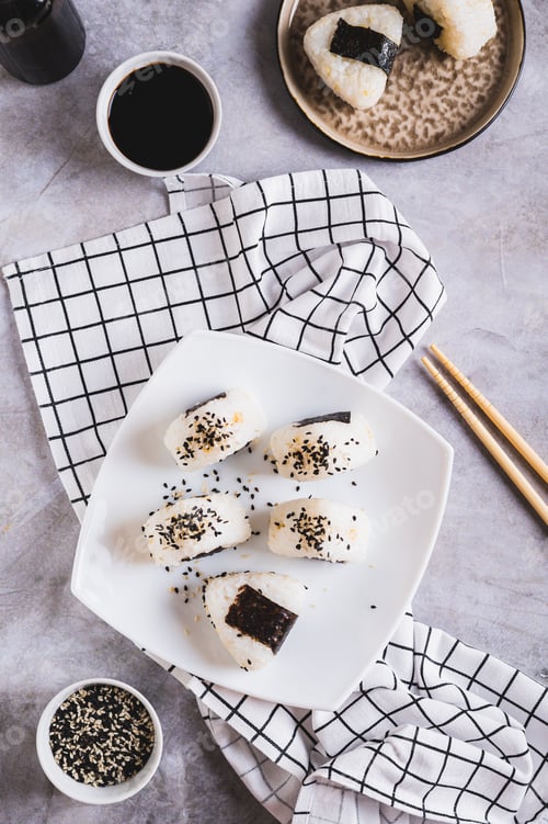 Preview: Homemade onigiri rice balls with tuna and nori on a plate on the table top and vertical view
