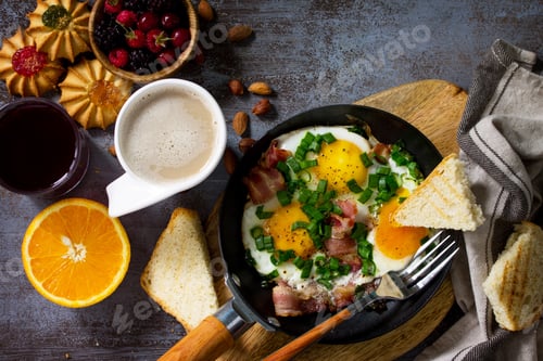 Preview: Breakfast scrambled eggs with bacon, coffee, berries, cookies, nuts and juice.
