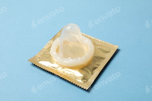 Preview: Close-up of an unpacked condom on a blue background