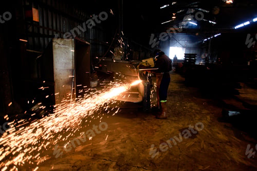Preview: Industrial worker with work tools with Lots of glowing sparks inside a factory