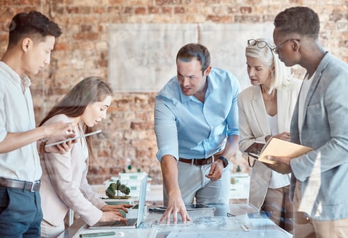 Preview: Group of diverse architects discussing plans, blueprints and schematics during a meeting in their o
