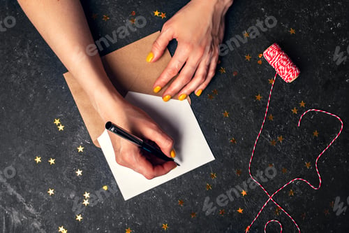 Preview: A woman writes plans for 2022 on black background top view
