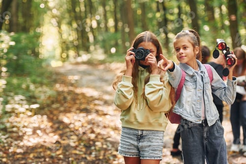 Preview: Front view of kids that is in green forest at summer daytime together