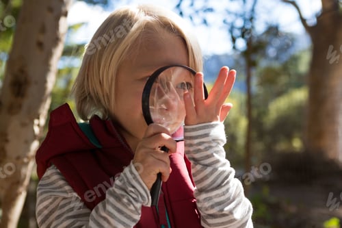 Preview: Smiling girl looking at a hand through a magnifying glass