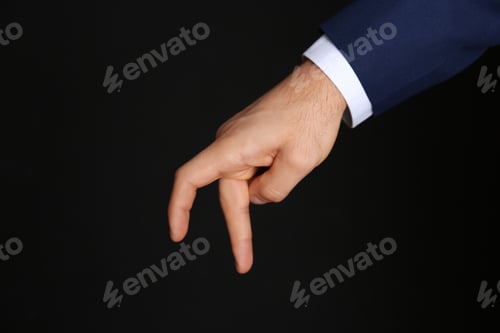 Preview: Businessman imitating walk with hand on black background, closeup. Finger gesture