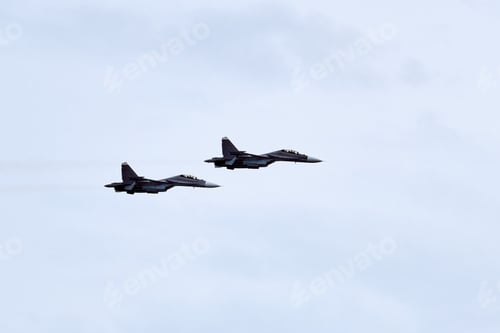 Preview: Two Russian military fighter planes armed with missiles flies in blue sky, airborne mission