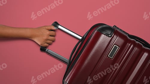 Preview: Woman with suitcase on pink background, ready for summer holidays. Top view with copy space.