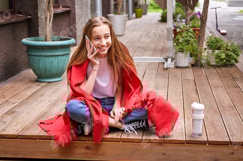 Preview: Smiling Teen Wrapped in Blanket Talking on Phone