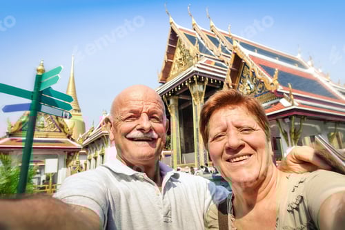 Preview: Senior happy couple taking a selfie at Grand Palace temples in Bangkok