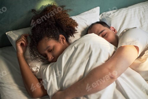 Preview: Young Caucasian Man Embracing Young Black Woman While Sleeping in Bed