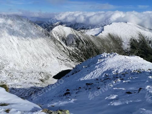 Preview: Majestic snow-covered mountain slope with icy peaks in the Retezat Mountains, Romania.