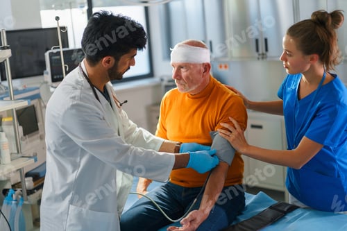 Preview: Young doctor and nurse treating injury of senior man.