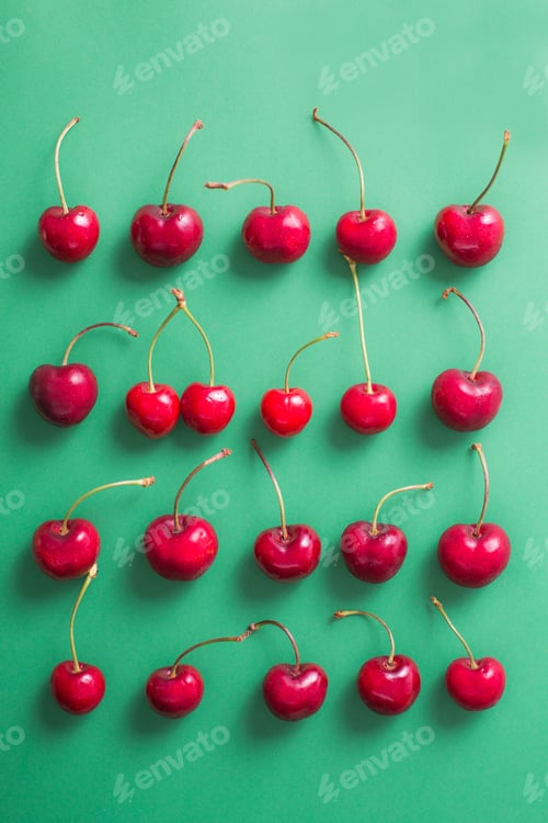 Preview: Top view of a group of cherries on green background