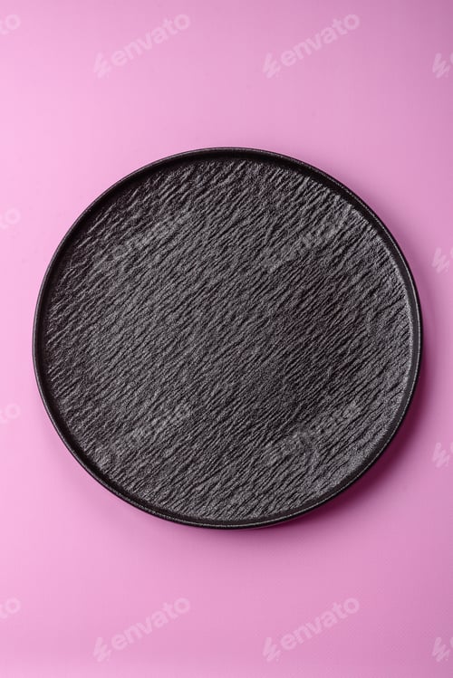 Preview: An empty round ceramic plate on a pink background as a kitchen utensil. An empty plate