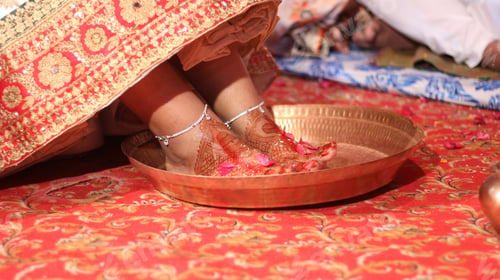 Preview: Closeup shot of a female feet with red paint put in a golden bowl