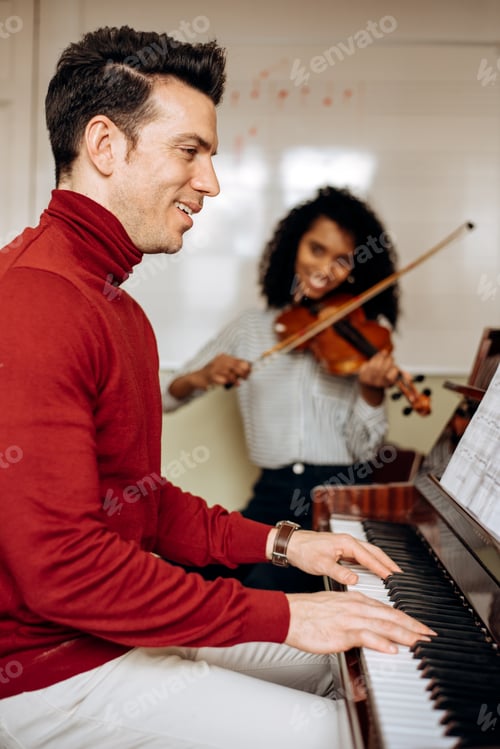 Preview: Man playing piano near woman playing violin in studio